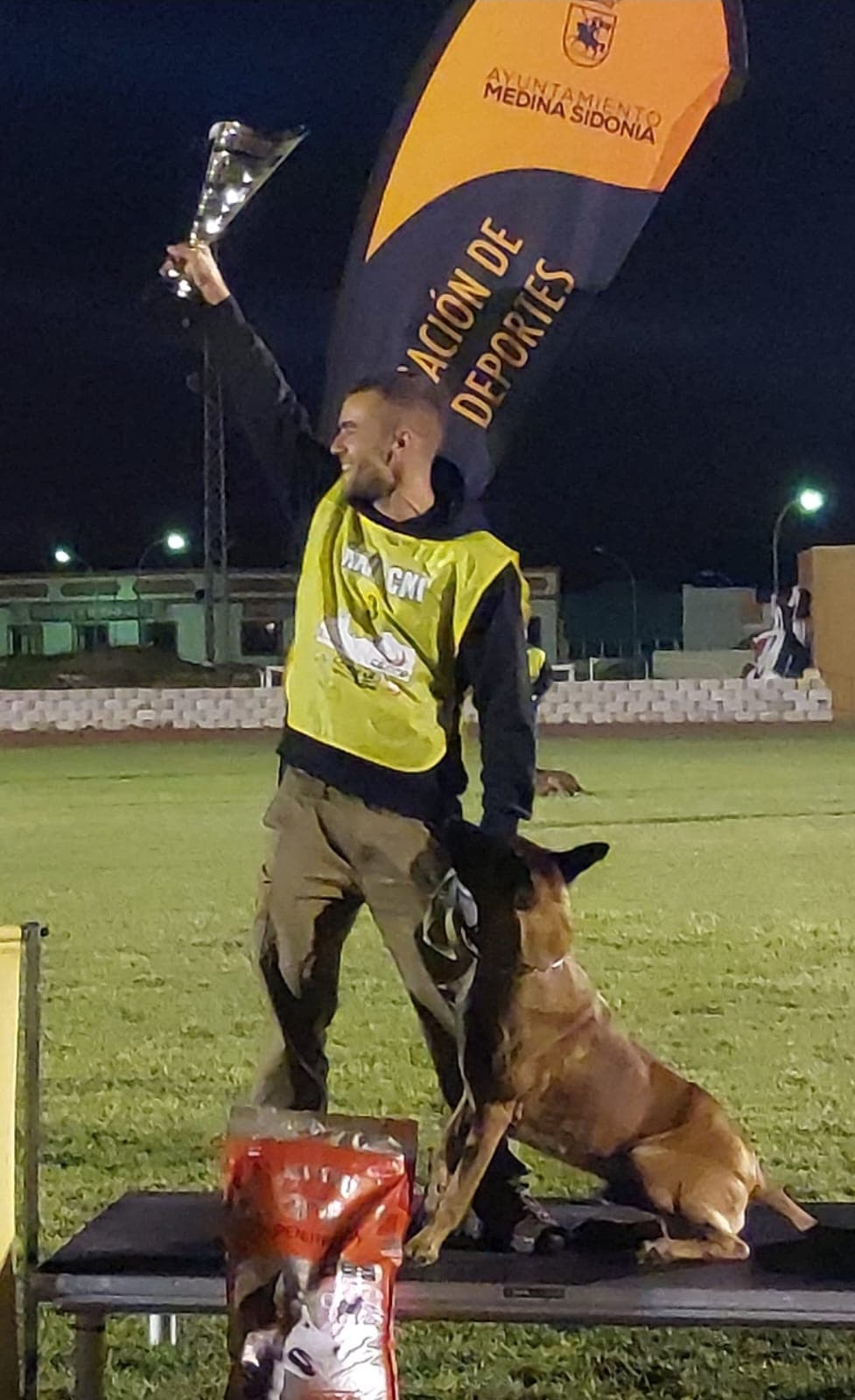 Gonzalo levantando un trofeo de IGP junto a su perro